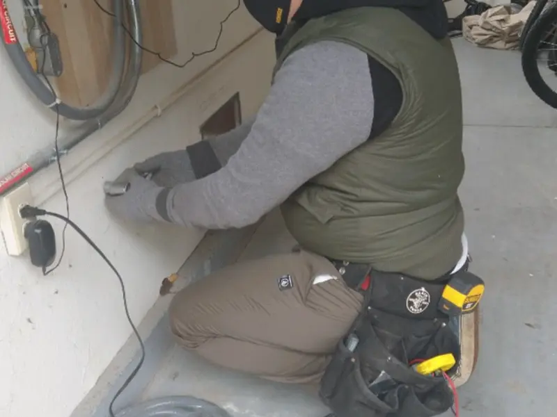 Electrician performing outlet wiring in a Olivehurst garage